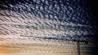 Silhouette of Construction Crane Against Dramatic Cloudy Sky
