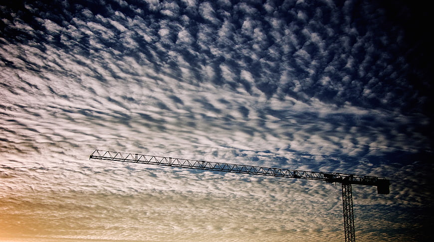 Silhouette of Construction Crane Against Dramatic Cloudy Sky
