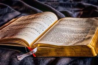 Open vintage hymnal with sheet music on dark fabric