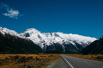 Scenic Mountain Road Leading to Snowy Peaks