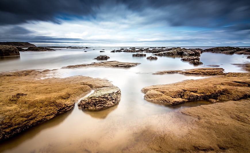 Dramatic Long Exposure Rocky Coastline with Misty Water