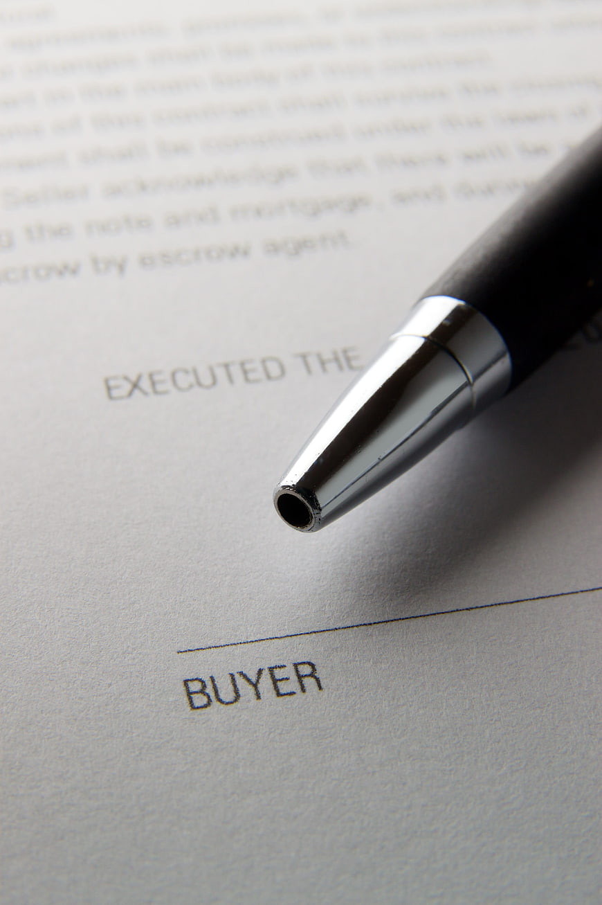 Close-up of pen on buyer signature line of contract