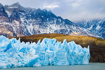 Majestic Blue Glacier with Snow-Capped Mountains Background