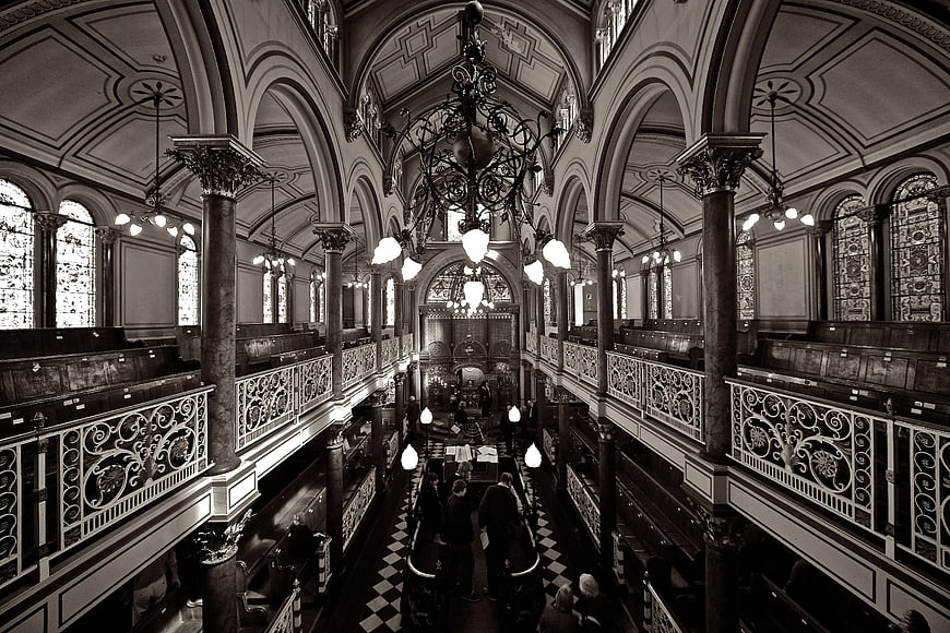 Black and white interior of ornate synagogue with chandelier