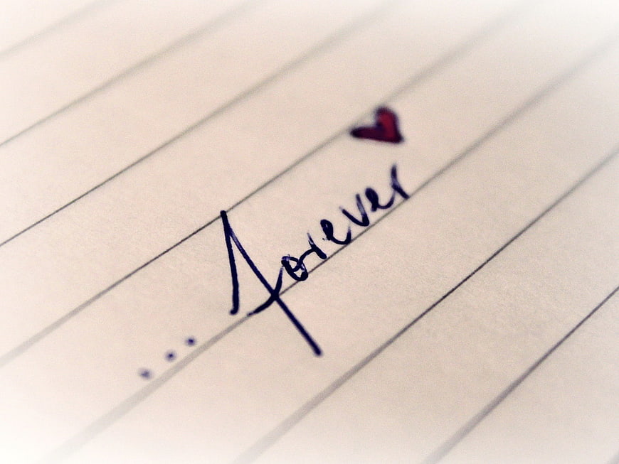 Handwritten word forever with heart on lined paper