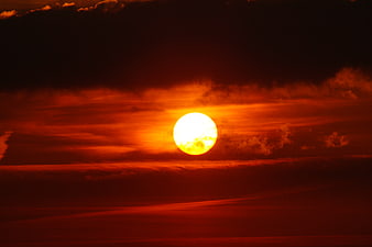Dramatic Red Sunset with Bright Sun and Dark Clouds