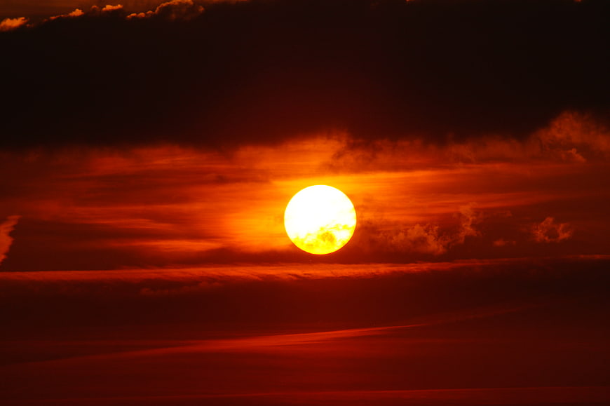 Dramatic Red Sunset with Bright Sun and Dark Clouds
