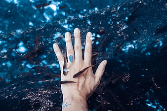 Underwater hand with blue fingerprint and swimming fish