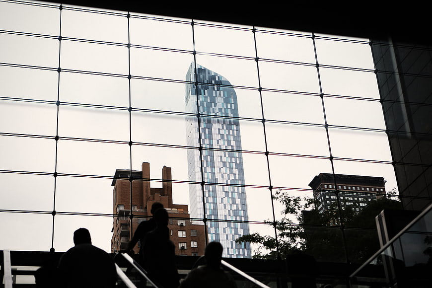 Silhouetted commuters on stairs against modern glass skyscraper