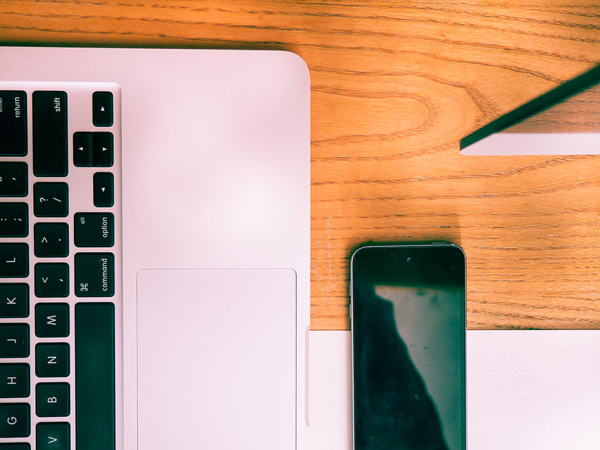 Top View of Laptop and Smartphone on Wooden Desk