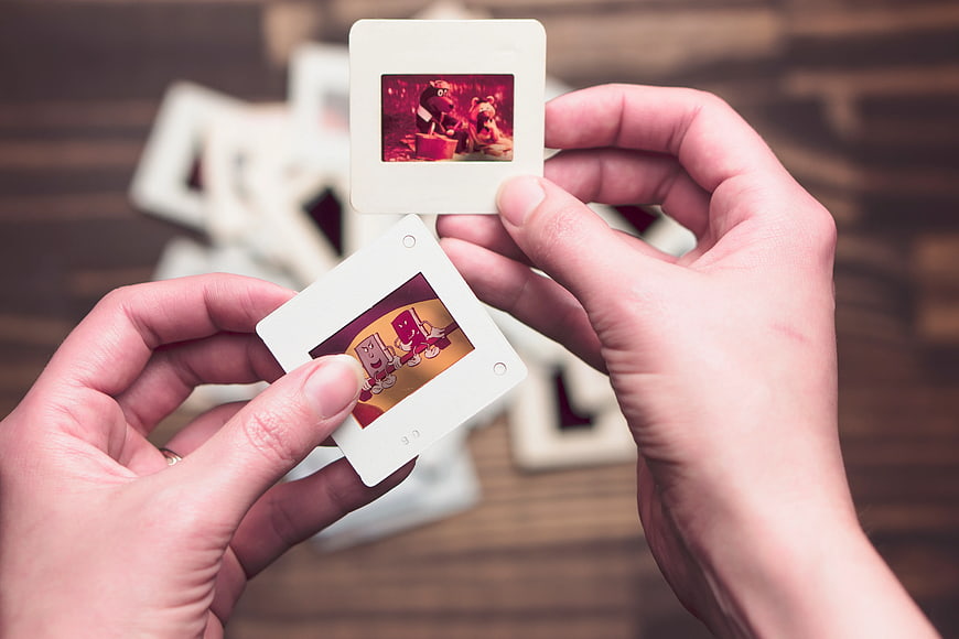 Hands holding instant photos with cartoon characters
