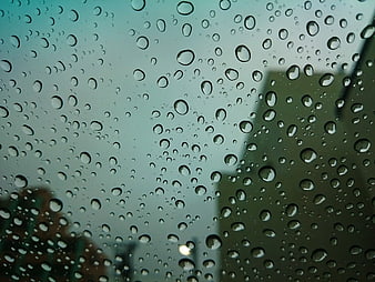 Raindrops on Window Glass with Blurred City Background