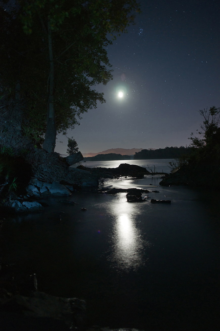 Moonlit River Landscape with Stars and Distant Mountains at Night