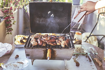 Grilling Chicken and Sausages on Outdoor Barbecue
