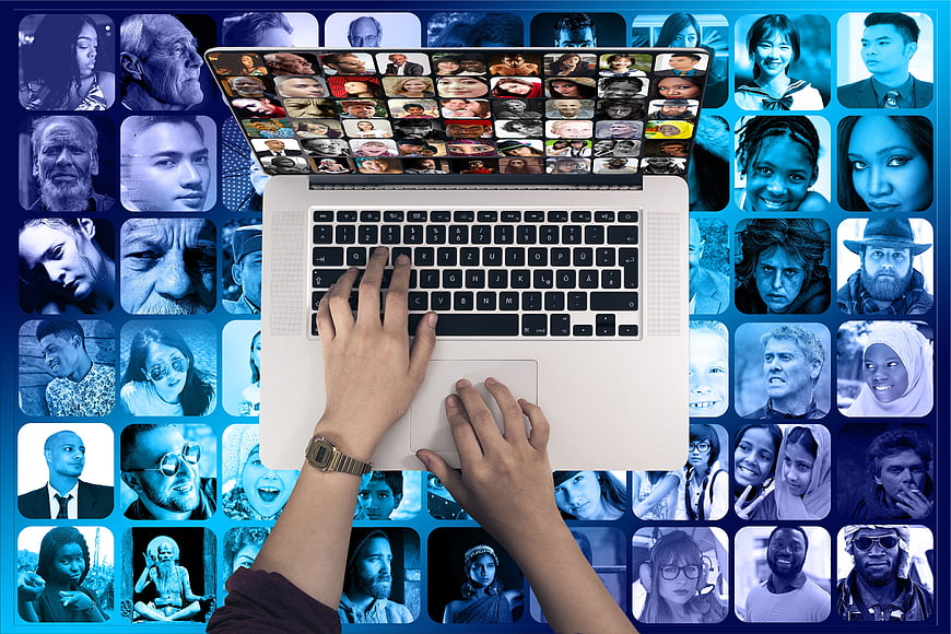 Hands typing on laptop with diverse faces background
