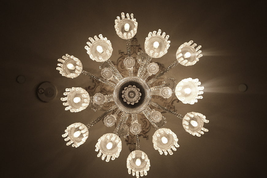 Low angle view of ornate crystal chandelier with warm lighting