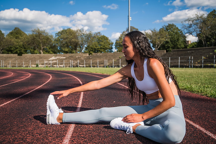 Woman Stretching on Outdoor Running Track