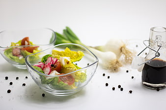 Fresh vegetable salad in glass bowls with dressing