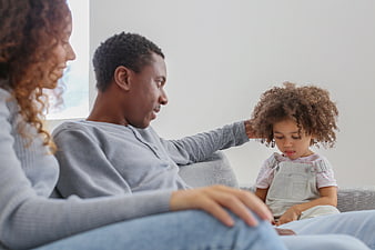 Happy African American Family Sitting on Sofa with Daughter