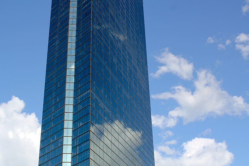 Modern Glass Skyscraper Against Blue Sky with Clouds