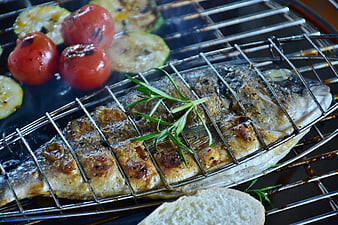 Grilled sea bream with rosemary and vegetables on barbecue