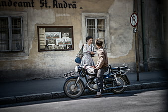 Vintage couple with classic motorcycle on European street