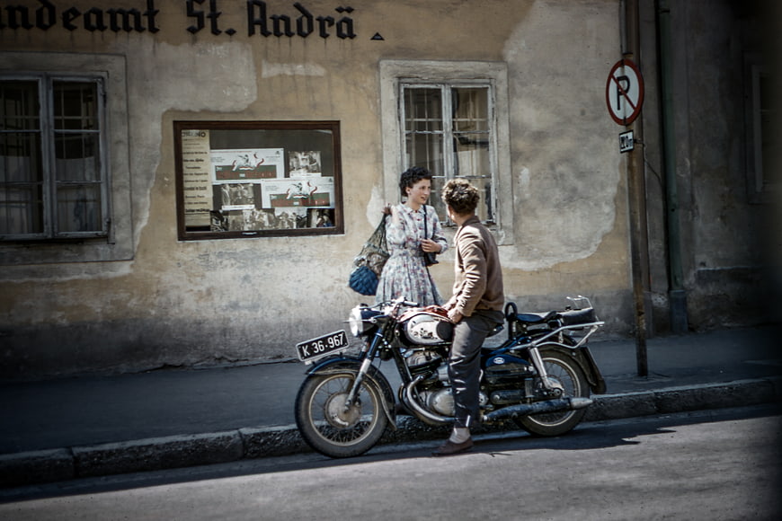 Vintage couple with classic motorcycle on European street