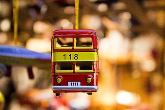 Close-up of a hanging red and yellow toy bus ornament