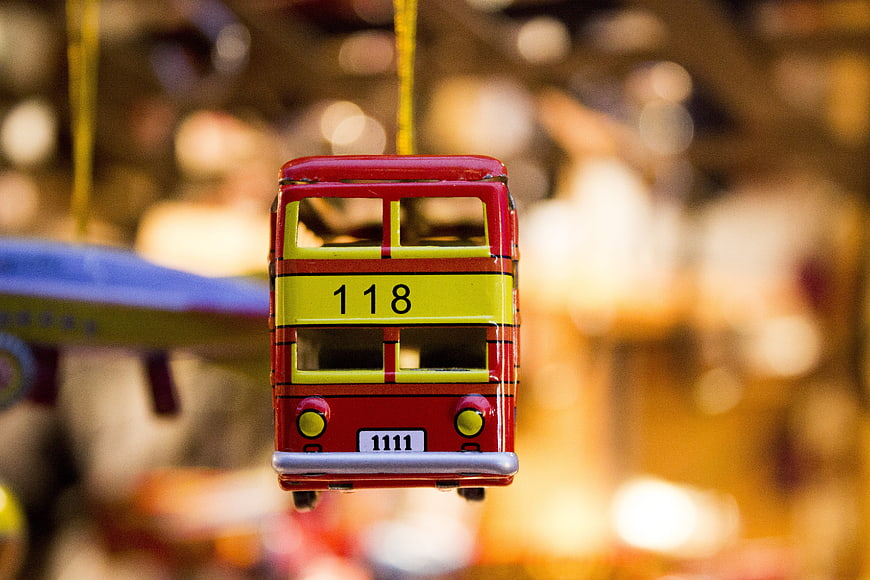 Close-up of a hanging red and yellow toy bus ornament