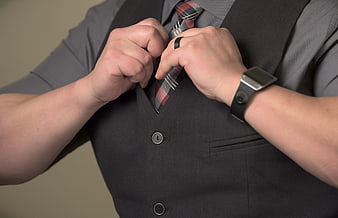 Businessman adjusting necktie and vest in professional attire