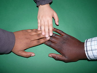 Diverse Hands Stacked Together on Green Background