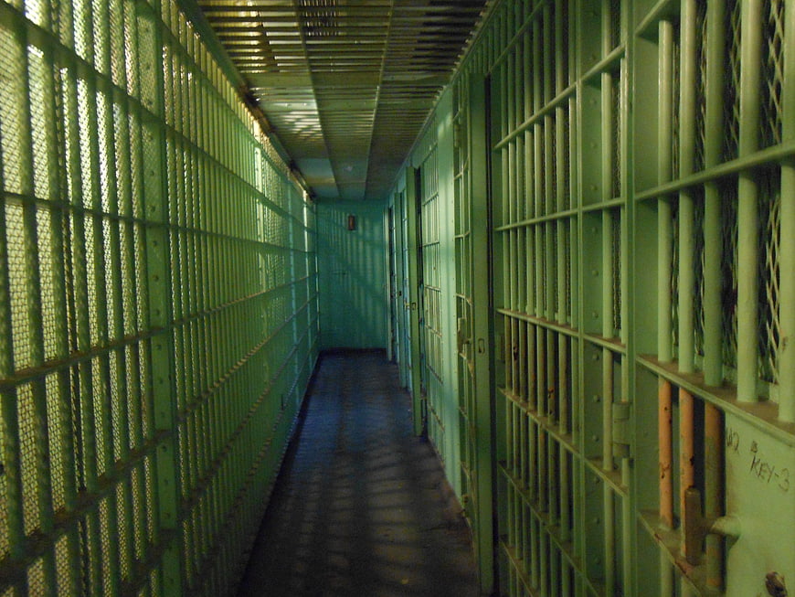 Empty Green Prison Cell Block Corridor With Metal Bars