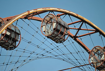 Rusty Ferris Wheel Structure Against Blue Sky