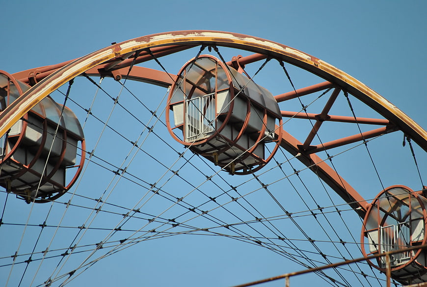 Rusty Ferris Wheel Structure Against Blue Sky