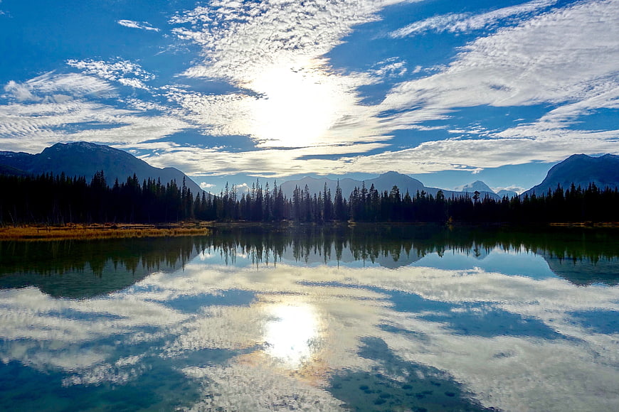 Serene mountain lake reflecting blue sky and clouds