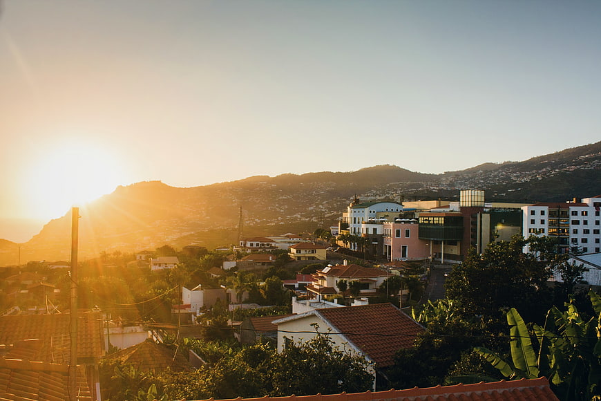 Golden Sunset Over Coastal Town with Mountains