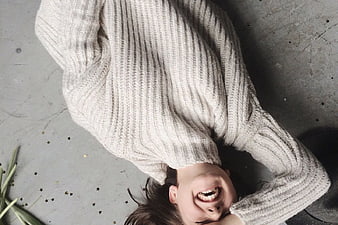 Laughing Woman in Oversized Sweater Lying on Floor