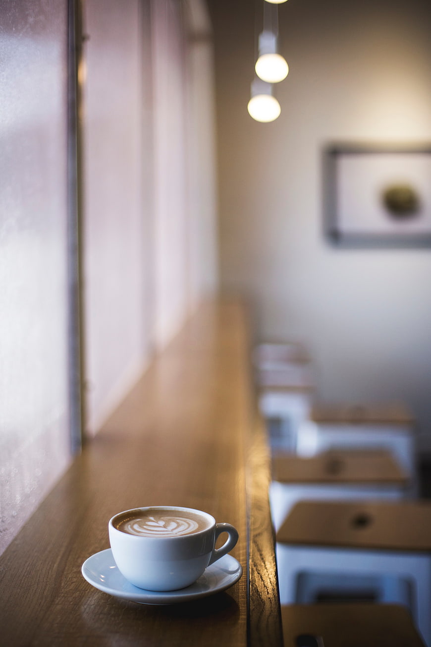 Latte Art Coffee Cup on Wooden Cafe Counter