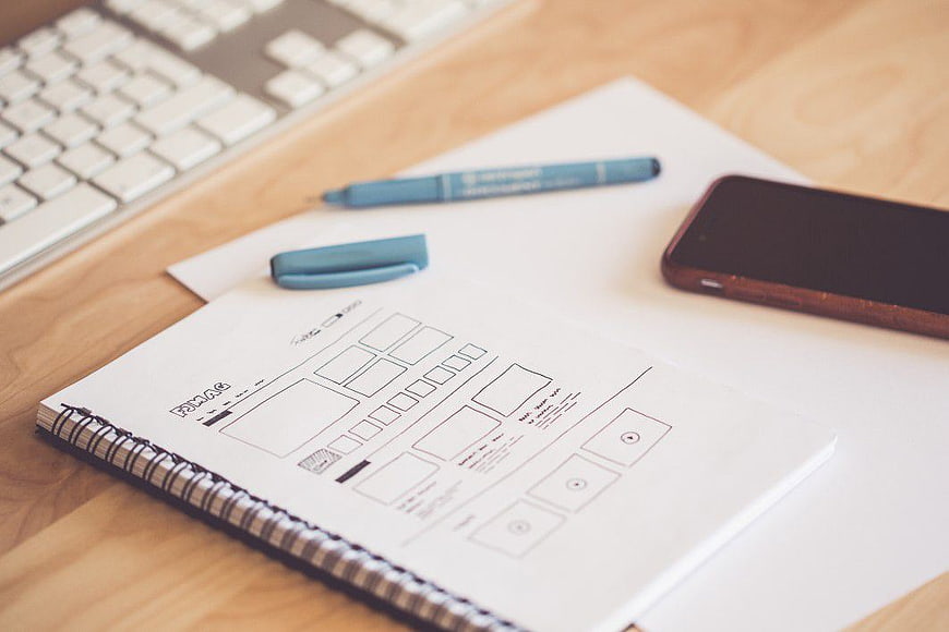 UX Wireframe Sketch on Notebook with Smartphone and Keyboard