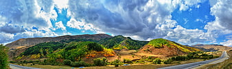 Panoramic View of Colorful Rolling Hills and Dramatic Cloudy Sky
