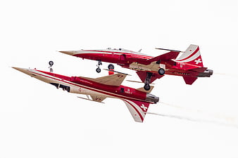 Two Red and White Swiss Air Force Pilatus PC-21 Jets Flying in Formation