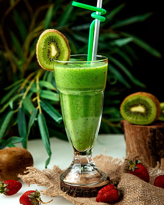 Fresh green kiwi smoothie with strawberries and straws