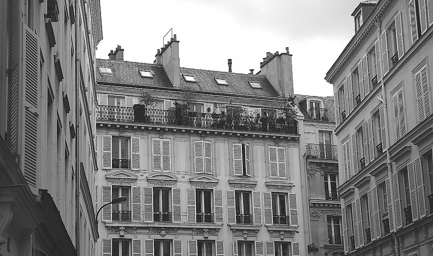 Black and white Parisian architecture with shutters and balconies
