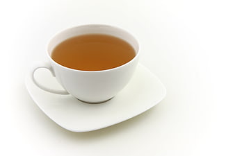 White teacup with amber tea on a square saucer against a white background