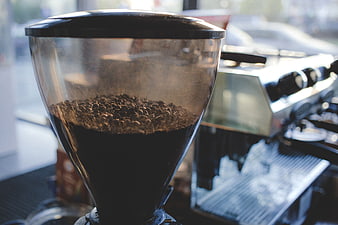 Coffee grinder with beans in a cafe setting