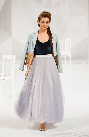Female model walking runway in pastel tulle skirt and light blue jacket