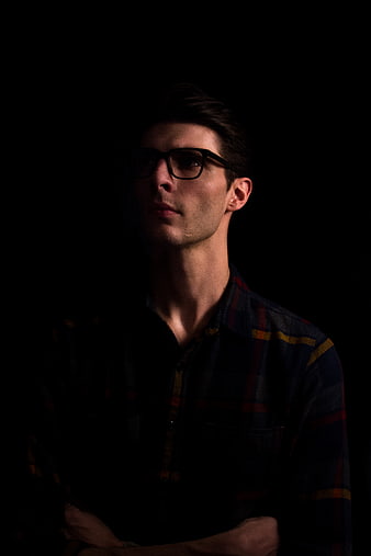 Dramatic Portrait of Man with Glasses in Dark Studio
