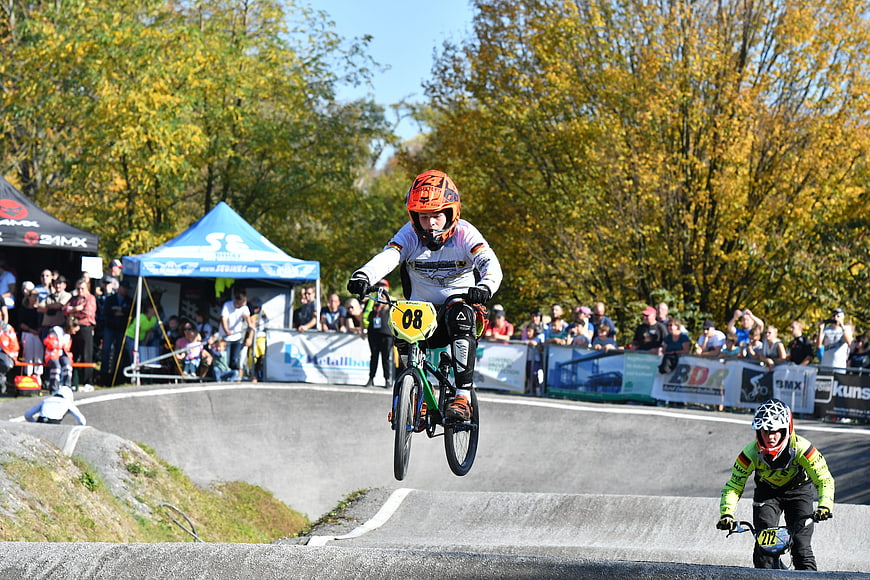 BMX Cyclist Jumping on Pump Track During Autumn Race