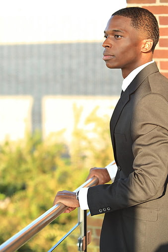 Young Black Man In Business Suit Standing On Balcony