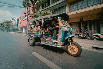 Colorful Tuk-Tuk Driving on Thai Street with Happy Passengers